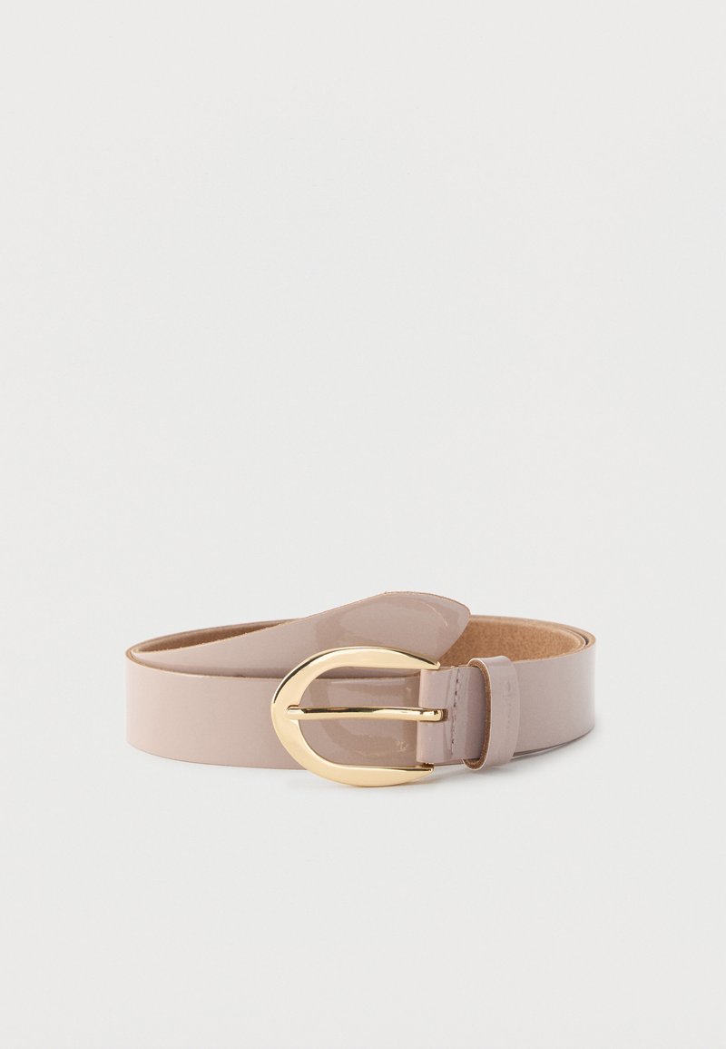 Ceinture en cuir beige brillant enroulée avec une grande boucle dorée arrondie sur fond blanc.