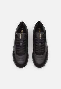 Schwarze Sneakers mit einer Kombination aus glatten und strukturierten Materialien, einem Schnürdesign und einer Gummisohle mit ausgeprägtem Profil. Größe 37.