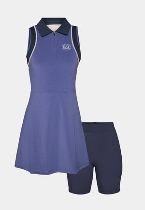 Lilla spordivest, millel on krae, pooltõmblukuga ja logo, koos tumehallide lühikestega. Omab sileda tekstuuri ja selget disaini.