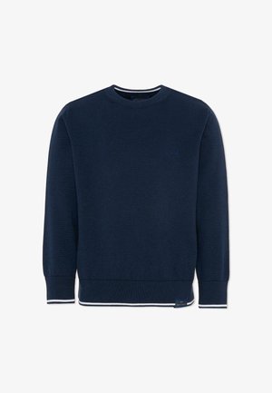 Granatowy sweter z dekoltem w szpic, długimi rękawami, ściągaczami przy rękawach i u dołu oraz subtelnym białym wykończeniem na mankietach i dolnym brzegu.