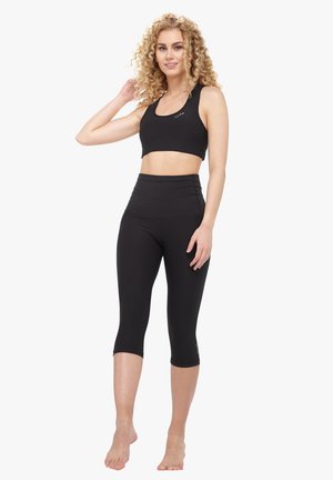 Black athletic crop top and high-waisted leggings, made of stretchy fabric. The top features a round neckline; leggings have a smooth finish.