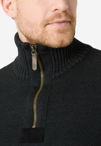 Schwarzer Strickpullover mit hohem Kragen und einem goldenen Reißverschluss. Verfügt über ein strukturiertes Muster und einen Wildlederakzent in der Nähe des Reißverschlusses.