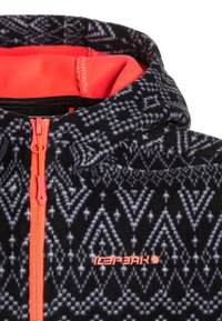 Giacca in pile nera con motivo geometrico in grigio e bianco, zip e fodera interna di un brillante colore arancione a contrasto, e cappuccio.