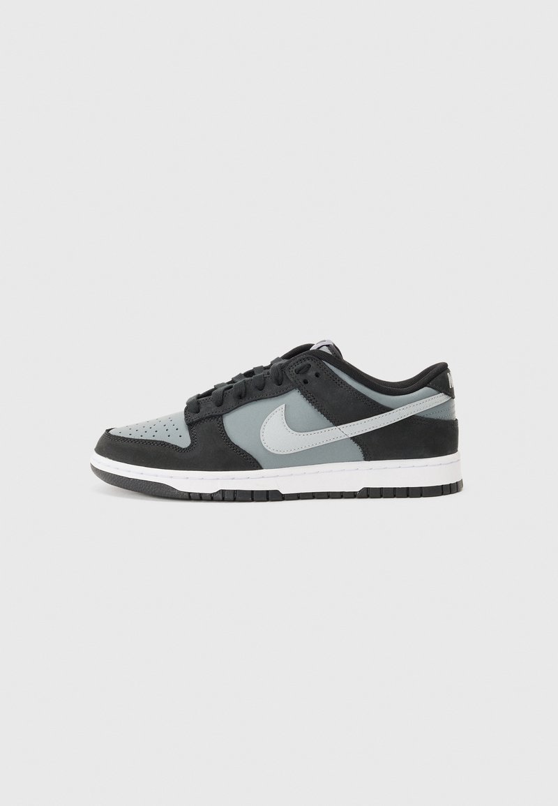 Czarno-szare sneakersy Nike Dunk wykonane ze skóry i zamszu, z perforowanym noskiem, gładkimi akcentami oraz białą podeszwą środkową i czarną podeszwą zewnętrzną.