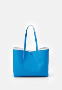 Sac fourre-tout en cuir bleu texturé avec bordure blanche et doubles anses épaules, arborant un petit logo embossé sur le devant.