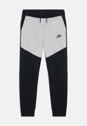 Czarno-szare spodnie dresowe Nike z sznurkiem w pasie, kieszeniami po bokach oraz logo Nike na górnej lewej części uda.