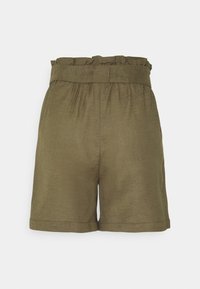 Short taille haute vert olive avec une ceinture froncée en forme de sac papier et des ourlets retroussés, vu de dos sur un fond uni.