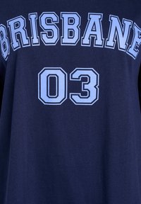 Tumšs zils T-krekls ar spilgti zilu tekstu, kas lasāms "BRISBANE" un "03." Izgatavots no mīkstas auduma, ar brīvu piegulumu un vienkāršu dizainu.