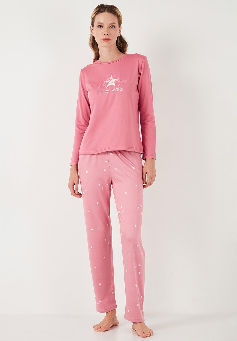 Camiseta de pijama de manga larga rosa con el texto "Me encanta el invierno" y un gráfico de estrellas; pantalones rosas a juego con patrones de estrellas blancas dispersas. Material suave.