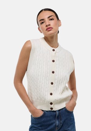 Gilet sans manches en tricot torsadé crème, avec un col rond et sept boutons marron sur le devant, doté d'une finition en côtes.