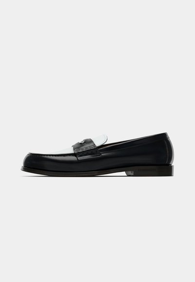 Mocassins en cuir noir à finition lisse, dotés d'un design cousu et d'un accent bleu clair. Comprennent un talon bas et un détail de marque.