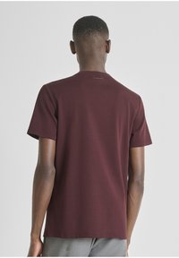 Burgundska majica kratkih rukava, pamučni materijal, okrugli izrez, jednostavan dizajn, s malim logotipom na stražnjem dijelu izreza, opušteni kroj.