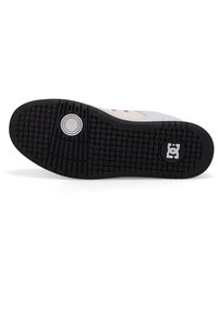 Black rubber sole with textured grip pattern. Features a gray upper with beige accents and a circular logo detail near the heel.