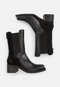 Stivaletti neri alla caviglia realizzati con una combinazione di pelle liscia e suede, dotati di pannelli laterali elasticizzati, punta quadrata e tacco impilato.