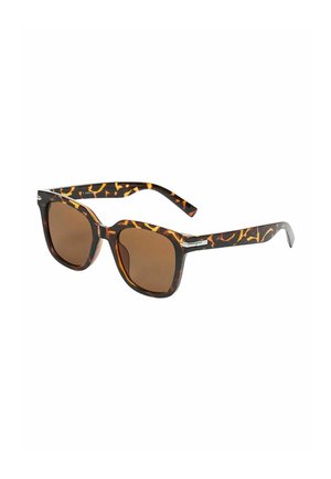 Lunettes de soleil écaille de tortue avec une forme carrée audacieuse. Verres marron, finition brillante et motifs clairs contrastants sur les branches. Détails en métal présents.