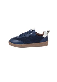 Sneaker in pelle e suede blu navy con suola in gomma marrone, presenta dettagli cuciti e un pratico passante sul retro per una facile indossabilità. Leggeri dettagli di perforazione.