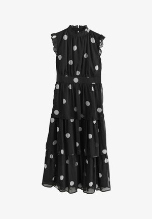 Black dress with white polka dots, tiered design, fabric features ruffled sleeves, high neckline, and a fitted waist.