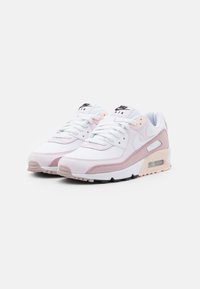 Buty sportowe Nike Air Max 90 w kolorach białym, jasnoróżowym i czarnym. Wykonane z siateczki i materiałów syntetycznych, z sznurowadłami oraz widoczną poduszką powietrzną w pięcie.