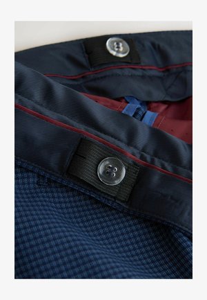 Tmavě modrá látka s kostkovaným vzorem a hladkou texturou. Obsahuje kontrastní vínové akcenty, zapínání na knoflíky a odolné švy.