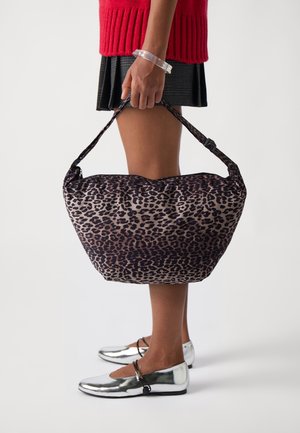 Leopardikuosisolkipussi, jossa on rakenteellinen, pehmeä muoto. Kankaan tekstuuri vaikuttaa sileältä. Tumma sävy, jossa vaaleanruskeita yksityiskohtia.