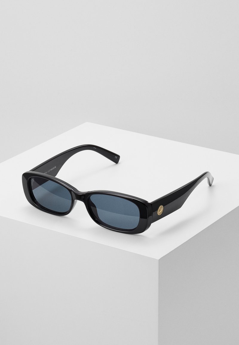 Black rectangular sunglasses with tinted blue lenses, thick frames, and a gold circular accent on the side. Sleek, shiny finish.