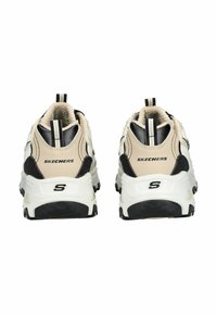Beige en zwarte Skechers sneakers met een gestructureerde mesh bovenkant, gevoerde kraag en chunky witte zool; heeft een logo op de hiel en de tong.
