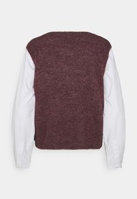 Maglione a maglia in bordeaux con maniche lunghe in cotone bianco, caratterizzato da un design senza cuciture e un collo arrotondato. Tessuto testurizzato.