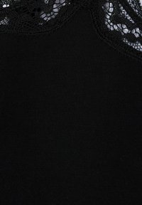 Černý textilní top s krajkovým výstřihem. Materiál je hladký s mírným leskem. Krajka má složitý květinový vzor.