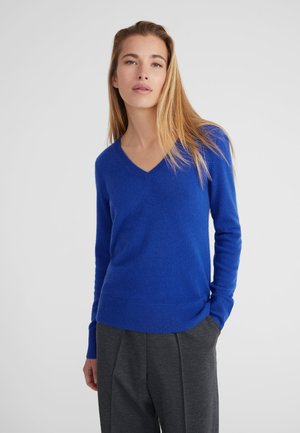 V-hals, lange mouwen trui in levendig blauw, gemaakt van zachte garen. Ribbelzoom en boorden, wat zorgt voor een strakke pasvorm.