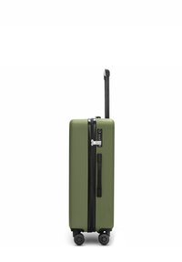 Groene harde koffer met zwarte rits, handgreep, vier wielen en een verlengbare telescopische handgreep, rechtopstaand op een witte achtergrond.