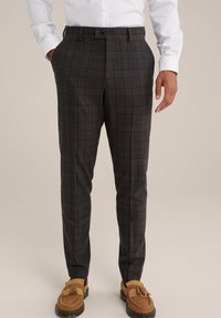 Pantalons gris à carreaux en tissu à texture fine, arborant une coupe slim et une fermeture à un bouton. Associés à des mocassins marron.