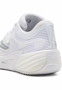 Λευκό αθλητικό παπούτσι με υφή από πλεκτό δίχτυ με οριζόντιες ρίγες, στρογγυλεμένη φτέρνα και καουτσούκ σόλα με διακοσμητικά λογότυπα Puma.