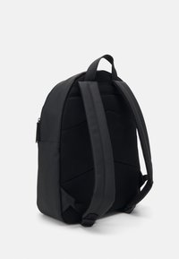 Svart ryggsäck med en slät yttertyg och mesh-bakstycke, med vadderade axelband och ett handtag på toppen för enkel transport.