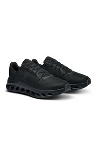 Chaussures de sport noires en maille texturée avec une semelle rembourrée dotée d'ouvertures pour la ventilation. Lacets et logo de couleur noire assortie.