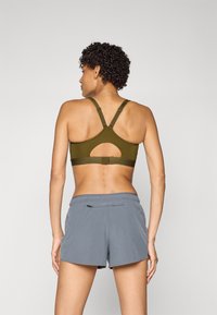 New Balance ESSENTIAL RUN BRA - Sportmelltartó közepesen nehéz sportoláshoz - woodland