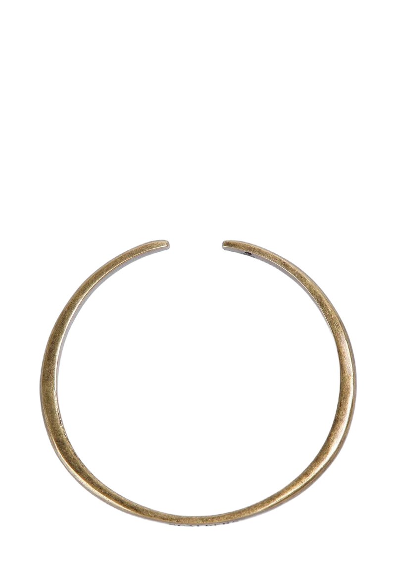 Pulsera de metal dorado con un acabado suave y pulido y un diseño minimalista, que presenta una forma ligeramente abierta.