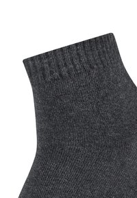 Calza grigia a coste con caviglia alta e elastica. Realizzata in materiale morbido e testurizzato, presenta un motivo a maglia liscia e un colore uniforme.