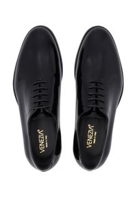 Černé lakované kožené polobotky s hladkým povrchem, zaoblenou špičkou, šněrovacím designem a zlatým logem na stélce.