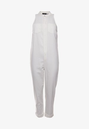Combinaison blanche sans manches avec fermeture à boutons sur le devant, deux poches poitrine, col montant et bas de pantalon retroussés.