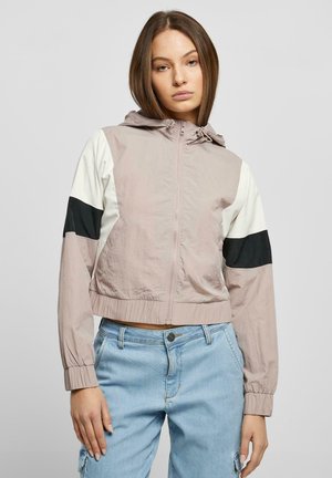 Lett cropped jakke med hette, glidelås og fargeblokkdesign i lys rosa, hvit og svart. Teksturert stoff med elastiske ermer.