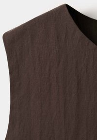 Vêtement sans manches marron foncé avec un tissu texturé et un col haut arrondi.