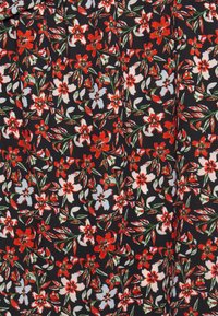 Tecido preto com um padrão floral, apresentando flores em vermelho, branco e azul claro, acentuadas por folhas verdes e detalhes intrincados por toda parte.