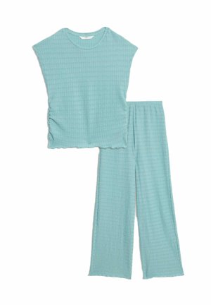 Lichtblauwe co-ord set met een getextureerd top met korte mouwen en een ronde halslijn, en wijde broek, beide met een ongelijkmatige zoomrand.