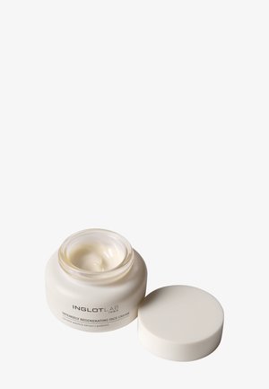 Pot ouvert de la crème visage régénérante intense InglotLab avec crème blanche à l'intérieur et le couvercle placé à côté sur fond blanc.