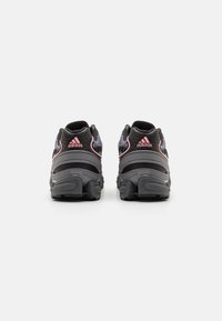 Black athletic shoes with pink accents, mesh upper, padded collar, and robust rubber sole. Features a low-profile design for comfort.
