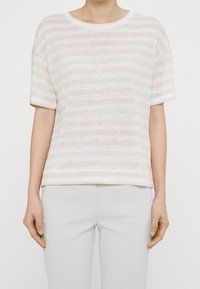 Top de manga corta a rayas en tonos beige claros, con un corte holgado y una tela suave y texturada. Dobladillo recto y cuello redondo.