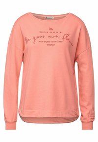 Rosa bomullströja med långa ärmar, med en vid halsringning och tryckt text: "VINTERTRÄDGÅRD VAR DIN EGEN BLOMMA."