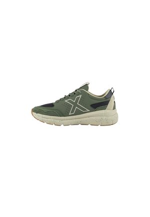 Zapatilla verde con acentos de malla negra, gráficos en blanco y una suela de goma texturizada. Cuenta con un collar acolchado y una pestaña de agarre.