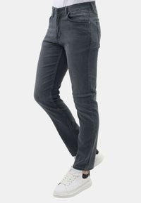 Grijze denim jeans met een slim fit, klassiek zakontwerp en een gladde textuur. Gepaard met witte sneakers met een zwarte accent.