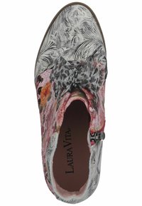 Botín de tobillo con estampado floral y abstracto, con un acento de lazo gris, que presenta una superficie texturizada y un cierre de cremallera lateral. Materiales de cuero.